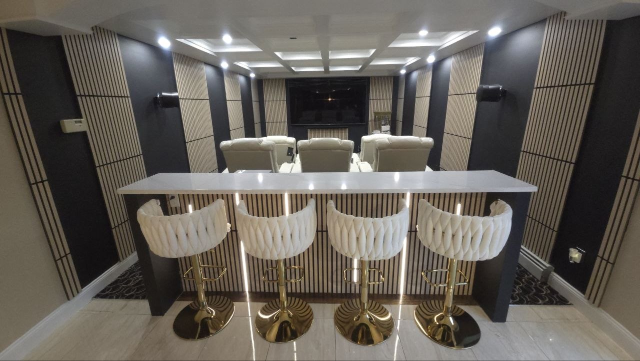Custom wall paneling, coffered ceiling, and trim work in a home theater